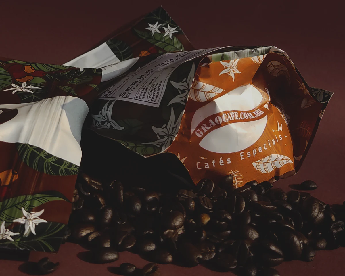 Embalagem Grão Café.com com ilustrações botânicas ao lado de grãos de café