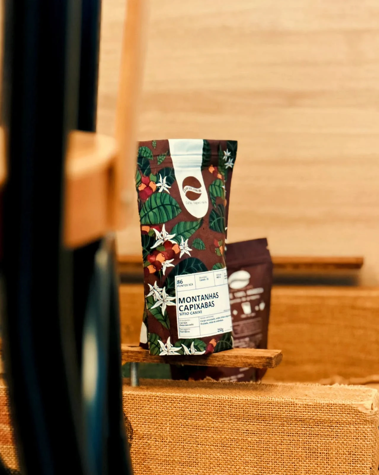 Pacote Grão Café.com fotografado sobre uma superfície de madeira